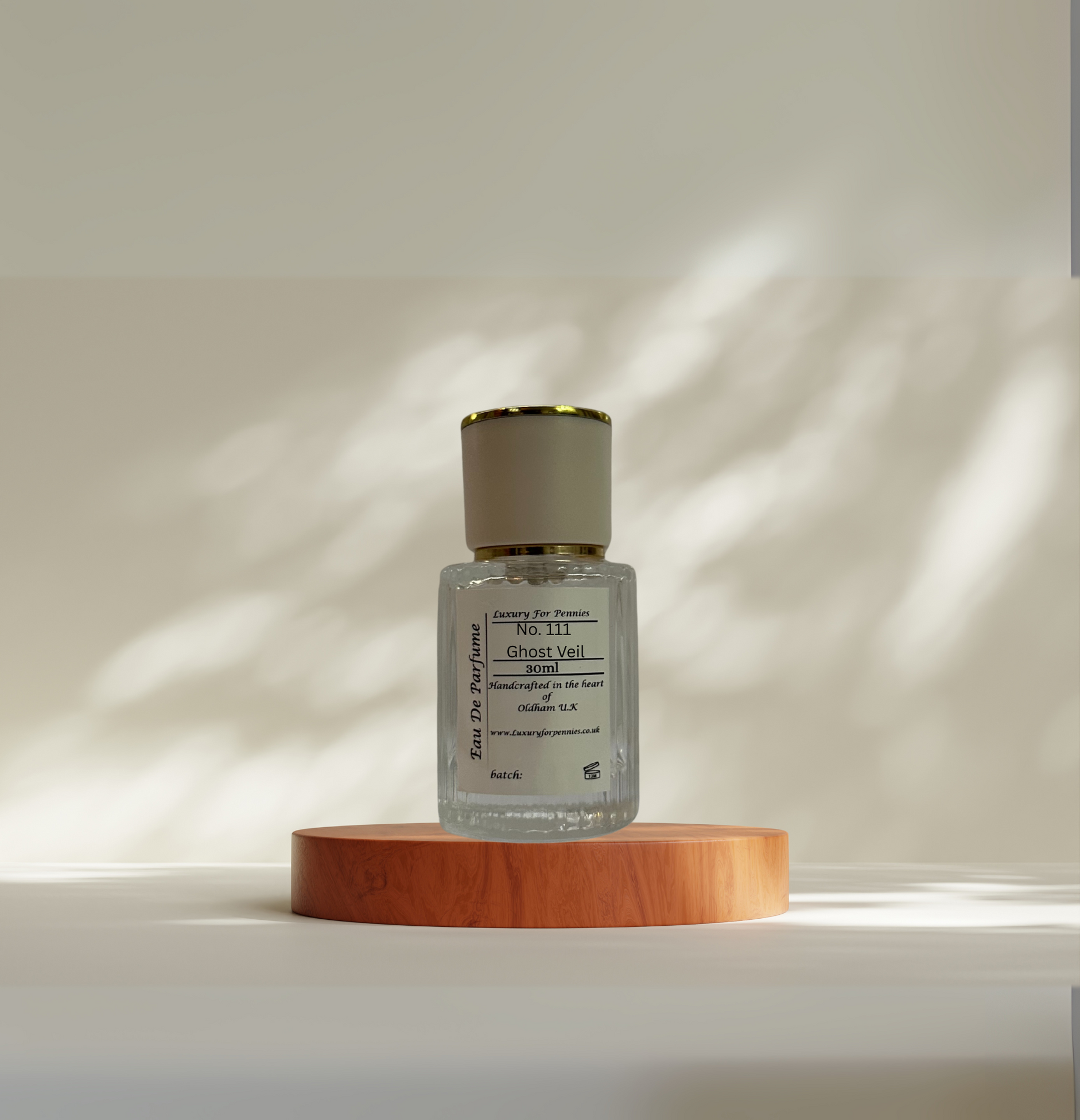 Small bottle with a gold cap on a wooden platform against a neutral background