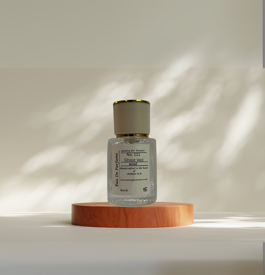 Small bottle with a gold cap on a wooden platform against a neutral background